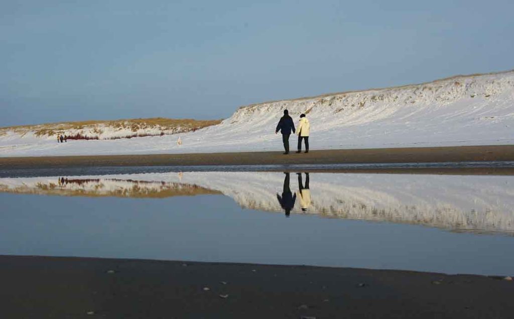 strand wandelaars sneeuw Texel spiegeling winter